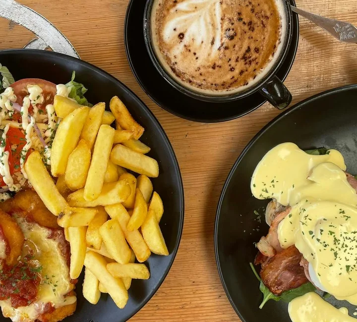 Chicken parmy, Eggs Benedict and coffee on the table at Harry’s