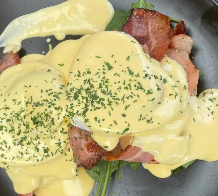 Eggs Benedict with bacon, baby spinach and hollandaise
